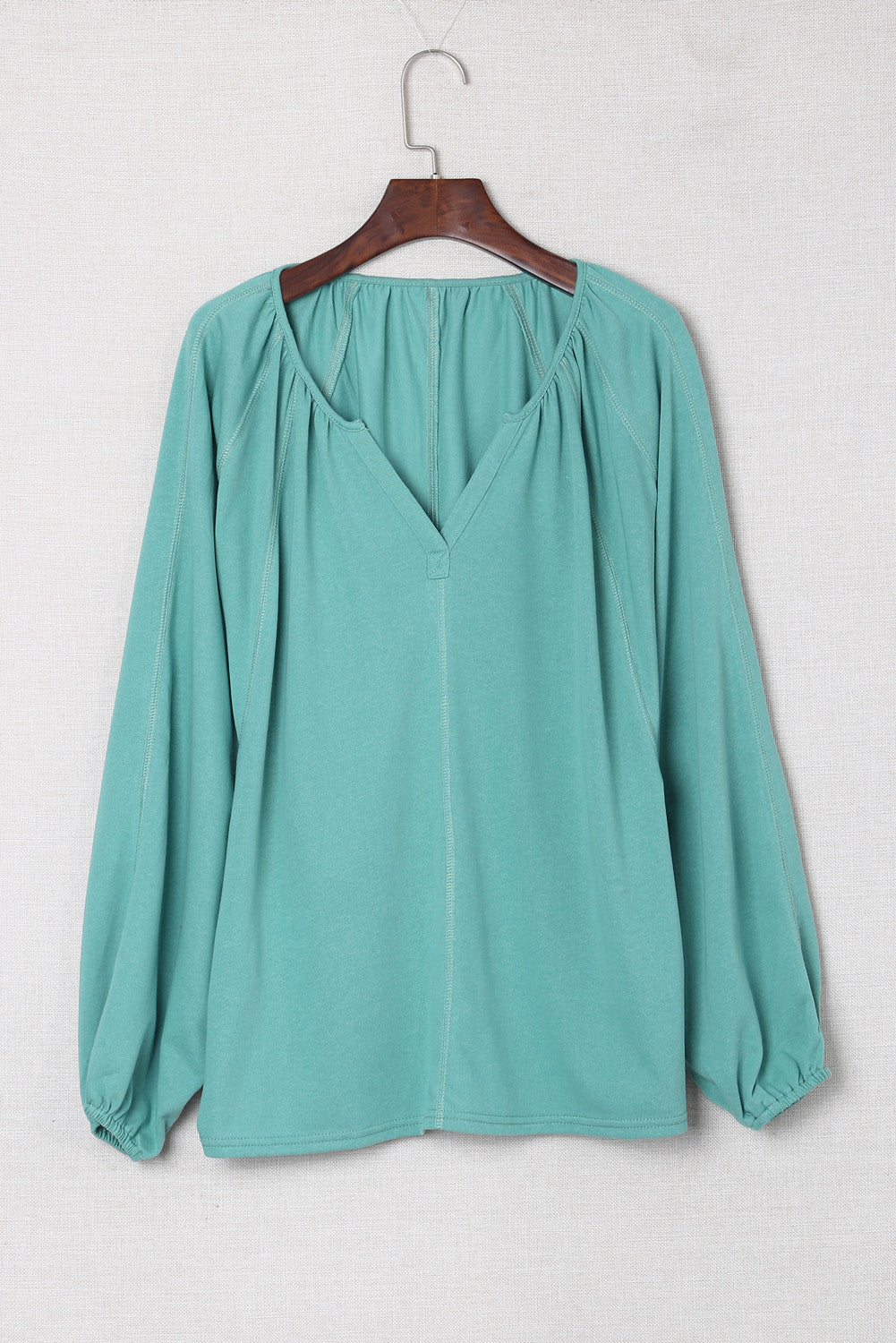 Gray Split V Neck Dolman Top featuring a relaxed fit, long sleeves with elastic cuffs, and a stylish high-low hemline.