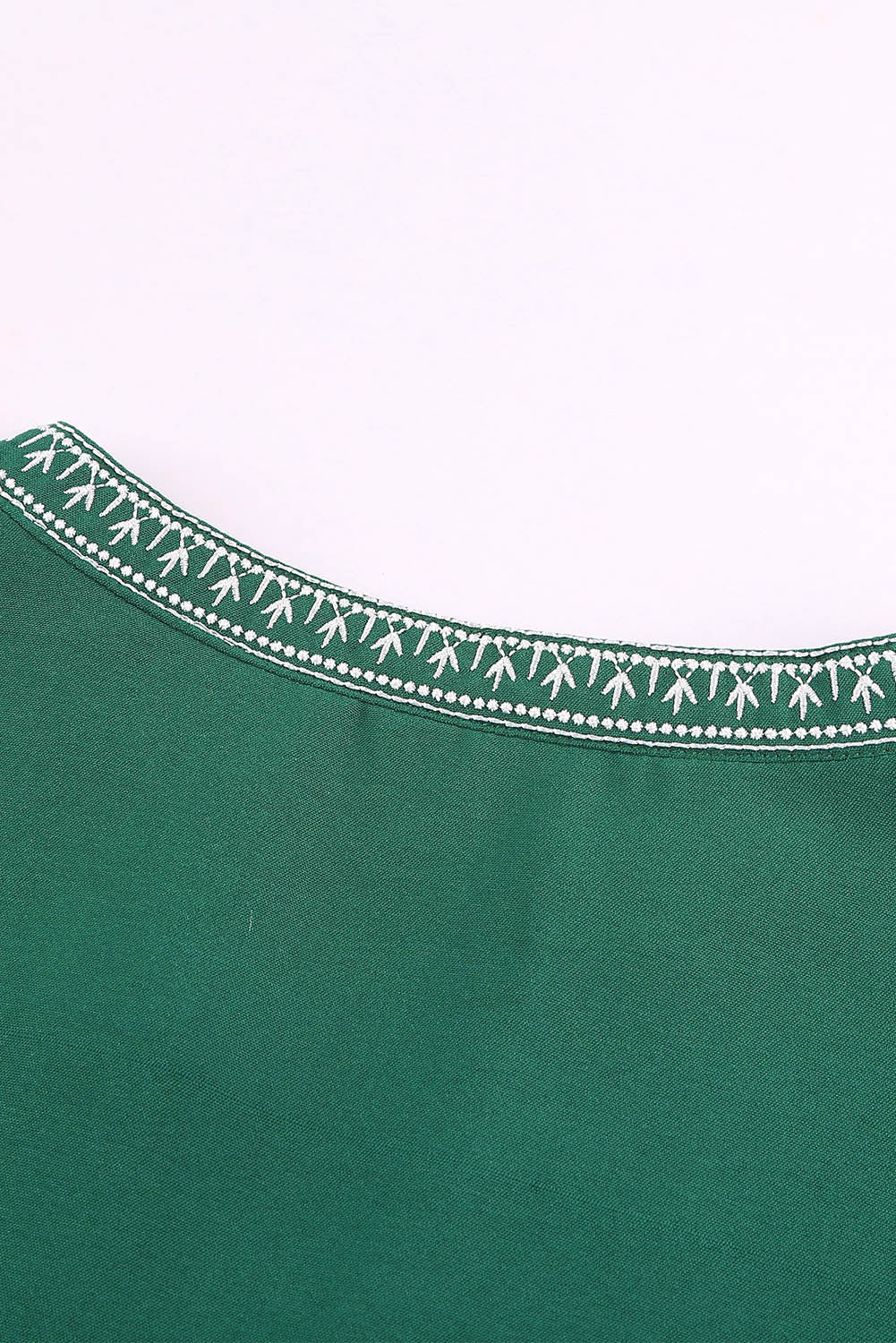 A stylish green boho blouse featuring a v-neckline and half sleeves with floral details, perfect for casual outings.