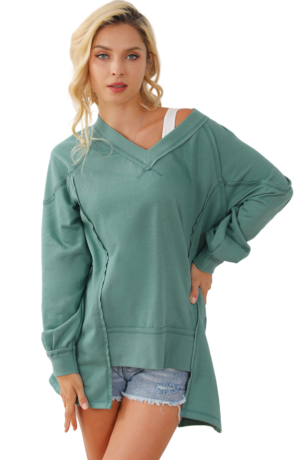 A stylish green high low sweatshirt featuring a V-neck and exposed seam detailing, perfect for casual wear.