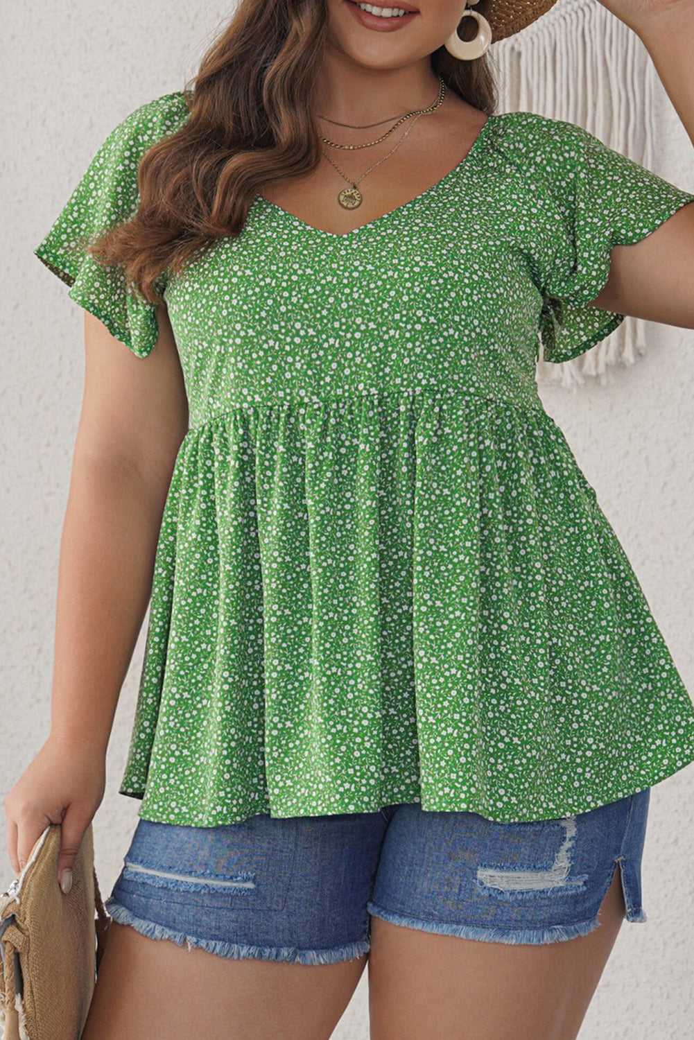 A stylish green plus size floral peplum top featuring a v-neck, flutter sleeves, and a flowy waist design, perfect for casual outings.