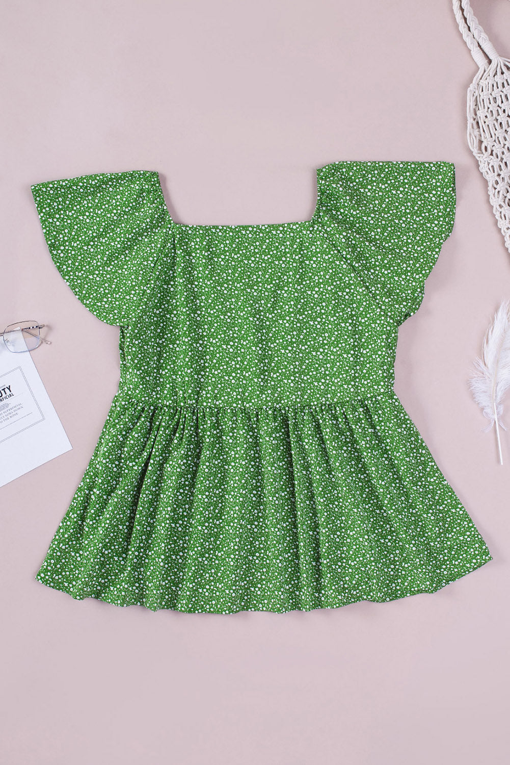 A stylish green plus size floral peplum top featuring a v-neck, flutter sleeves, and a flowy waist design, perfect for casual outings.