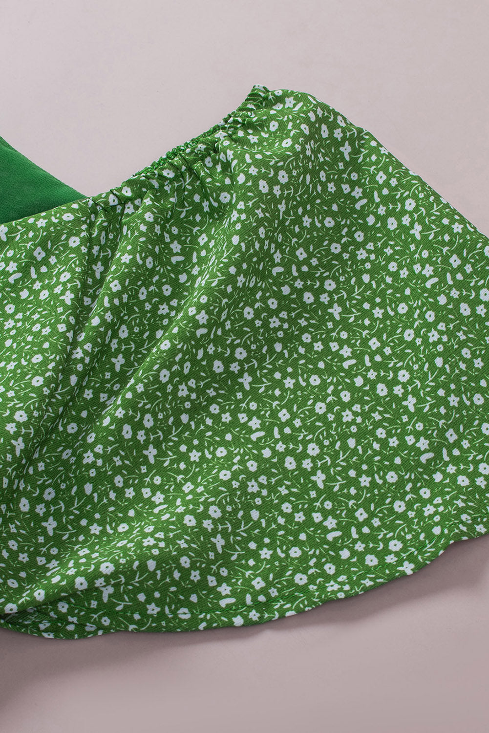 A stylish green plus size floral peplum top featuring a v-neck, flutter sleeves, and a flowy waist design, perfect for casual outings.