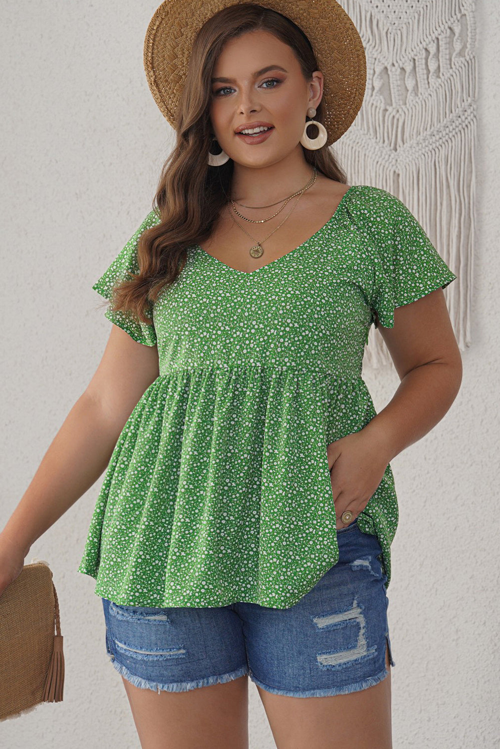 A stylish green plus size floral peplum top featuring a v-neck, flutter sleeves, and a flowy waist design, perfect for casual outings.
