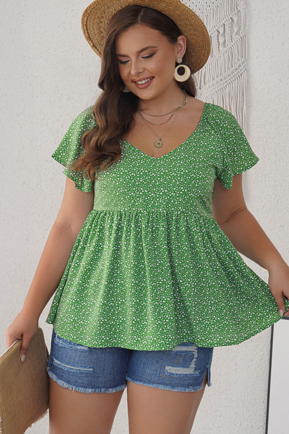 A stylish green plus size floral peplum top featuring a v-neck, flutter sleeves, and a flowy waist design, perfect for casual outings.