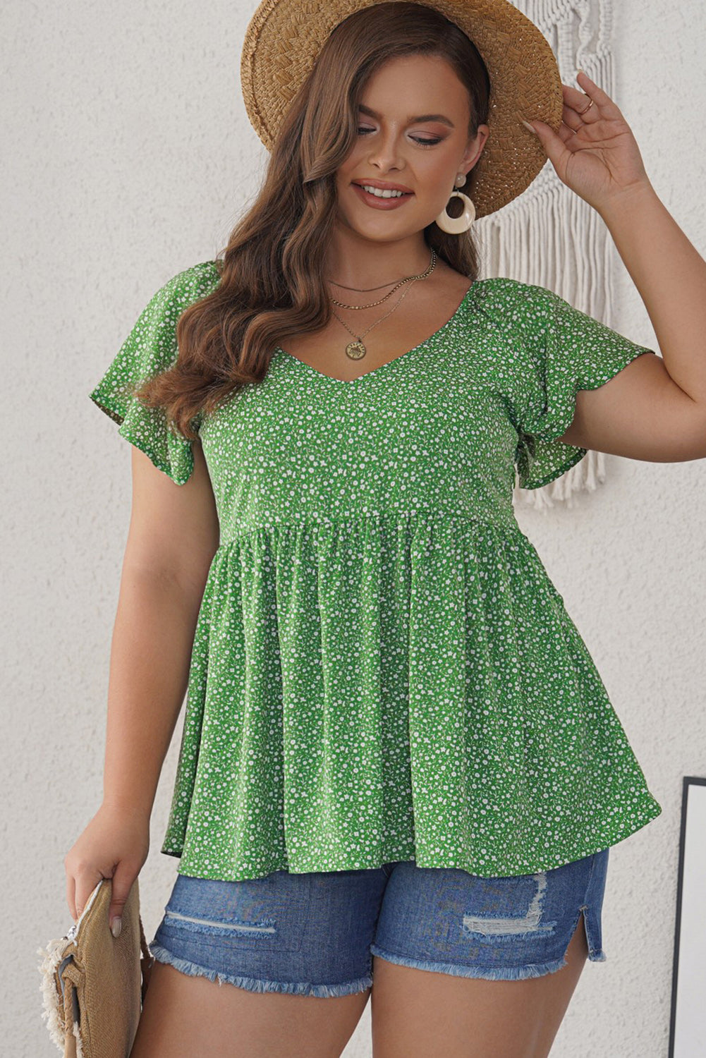 A stylish green plus size floral peplum top featuring a v-neck, flutter sleeves, and a flowy waist design, perfect for casual outings.