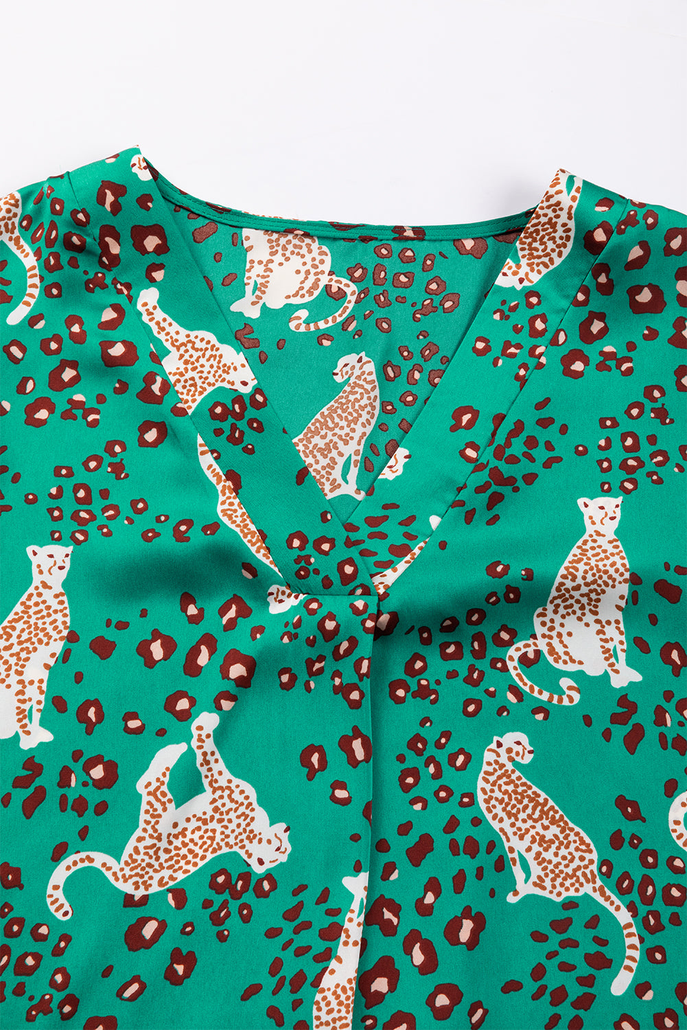 A stylish green blouse featuring a cheetah print design, V-neck, and flowy silhouette, perfect for casual wear.