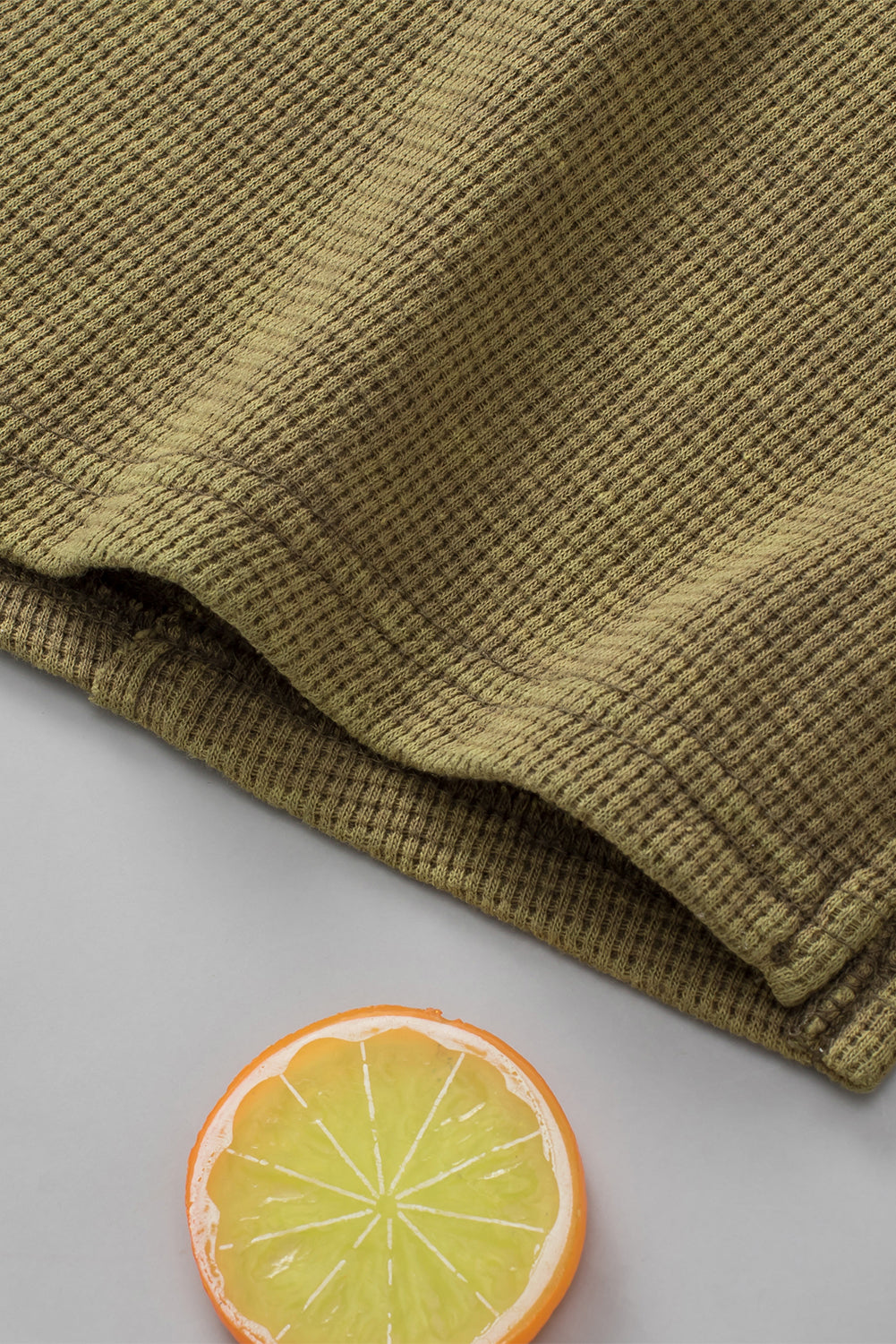 A stylish green long sleeve top with raw seams and a relaxed fit, perfect for casual wear.