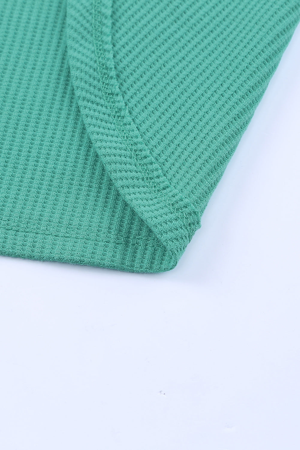 A stylish green waffle knit long sleeve top featuring splicing buttons and a crew neckline, perfect for casual wear.