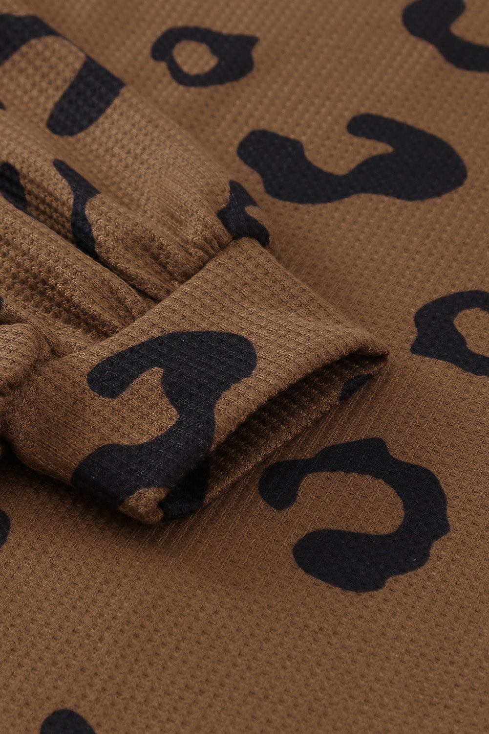 A stylish leopard print top featuring a side split design, V-neckline, and long sleeves, perfect for casual wear.