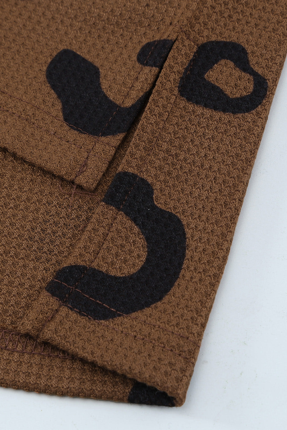 A stylish leopard print top featuring a side split design, V-neckline, and long sleeves, perfect for casual wear.