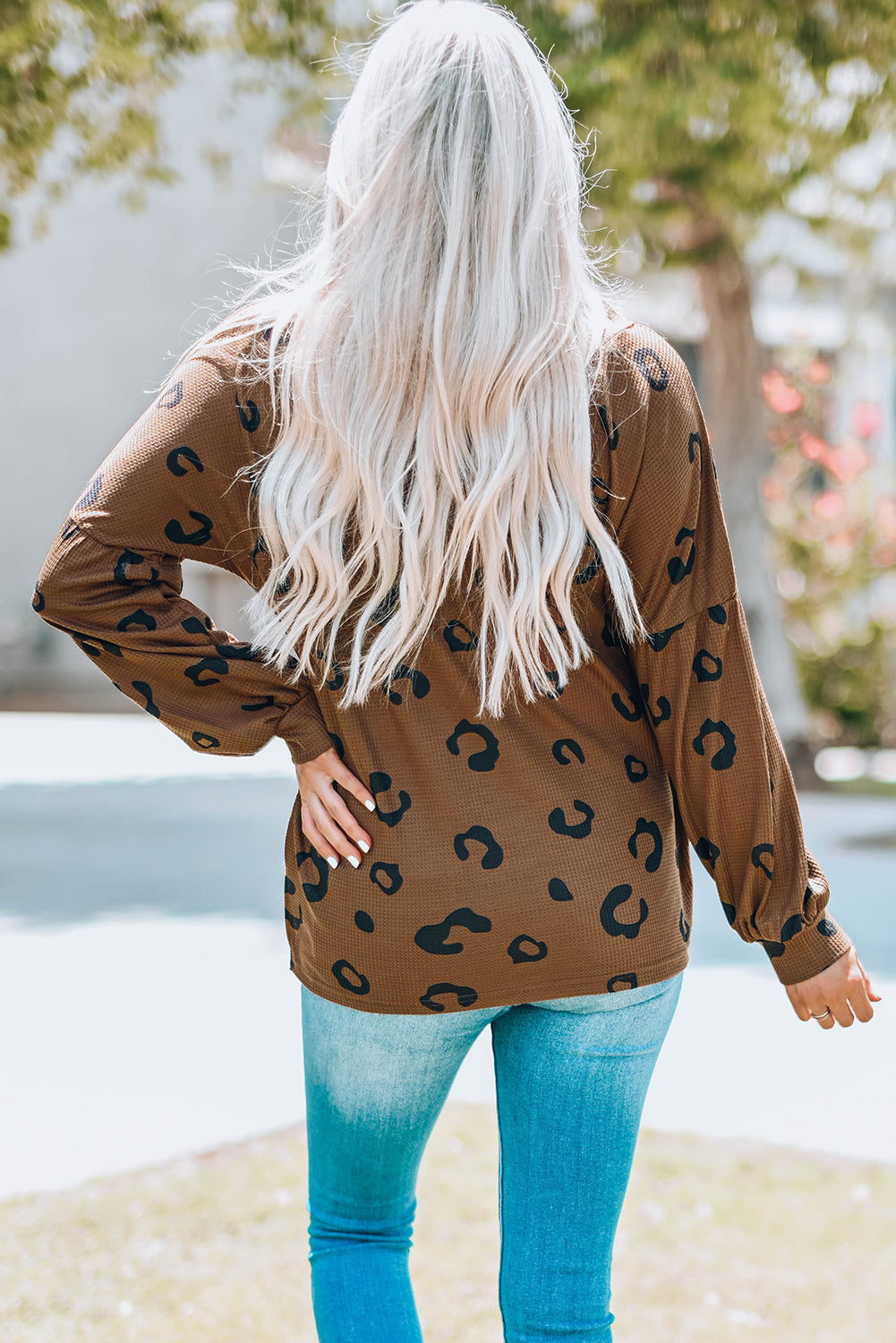 A stylish leopard print top featuring a side split design, V-neckline, and long sleeves, perfect for casual wear.