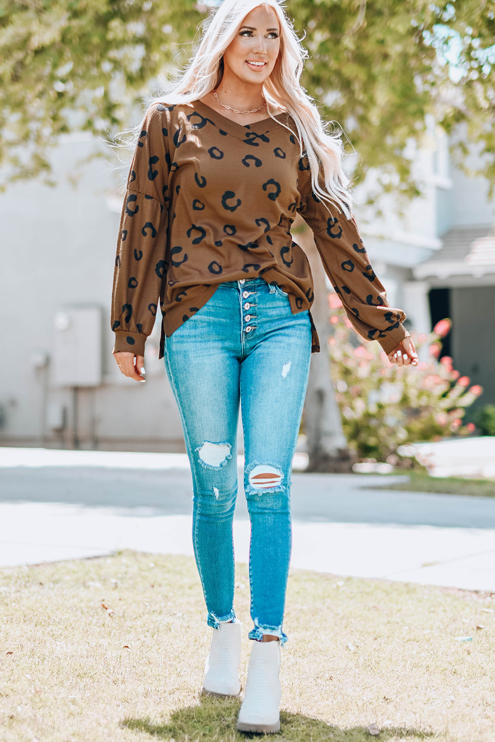 A stylish leopard print top featuring a side split design, V-neckline, and long sleeves, perfect for casual wear.
