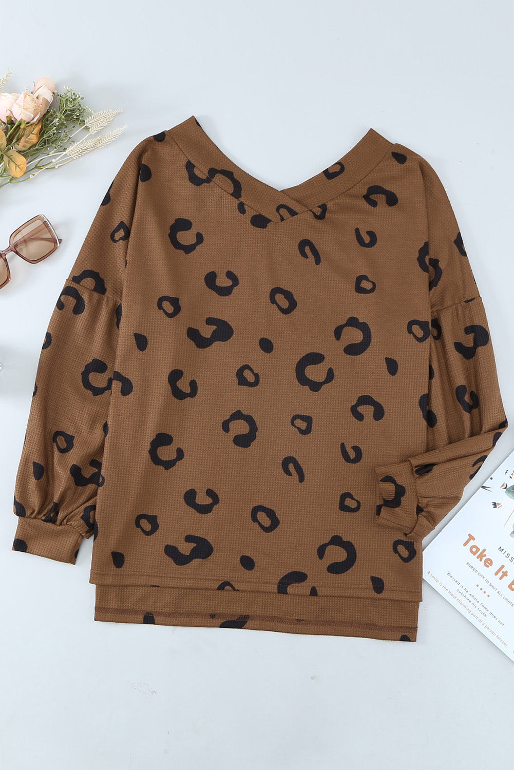 A stylish leopard print top featuring a side split design, V-neckline, and long sleeves, perfect for casual wear.