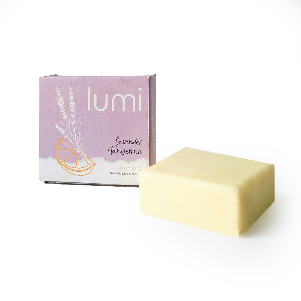 A solid lotion bar in a square shape, featuring a sweet lavender citrus scent, placed on a wooden surface with natural elements around it.
