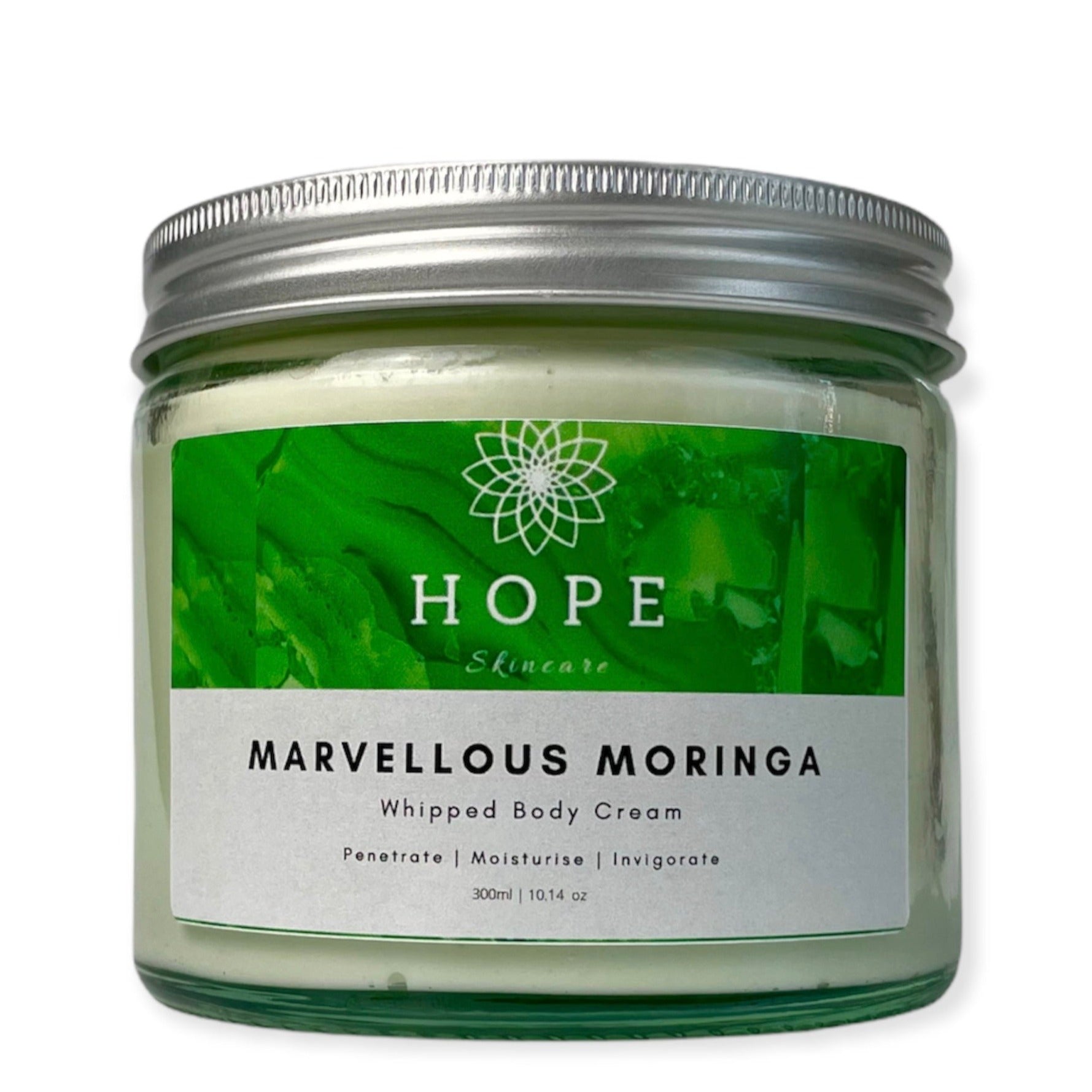 A jar of Marvellous Moringa Whipped Body Cream with a smooth, creamy texture, surrounded by Moringa leaves and Bergamot fruit.