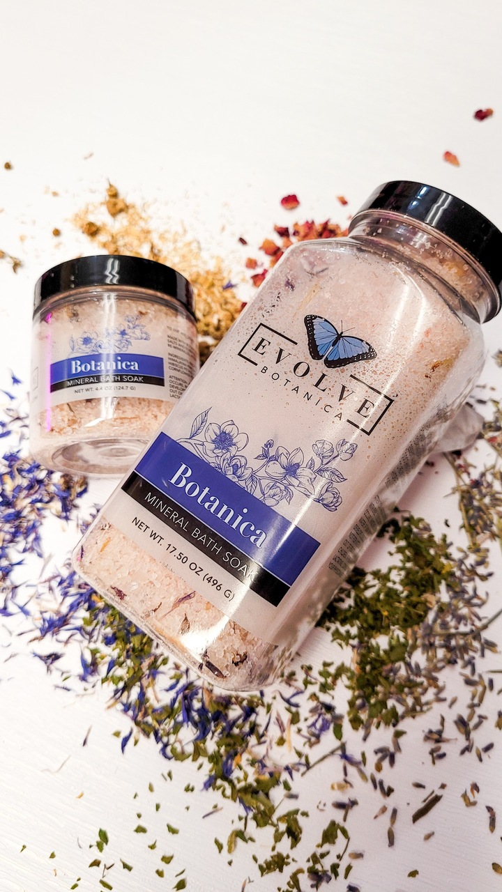 A jar of Mineral Soak - Botanica bath salt featuring a blend of Himalayan pink salt, Dead Sea salts, and colorful flower petals.