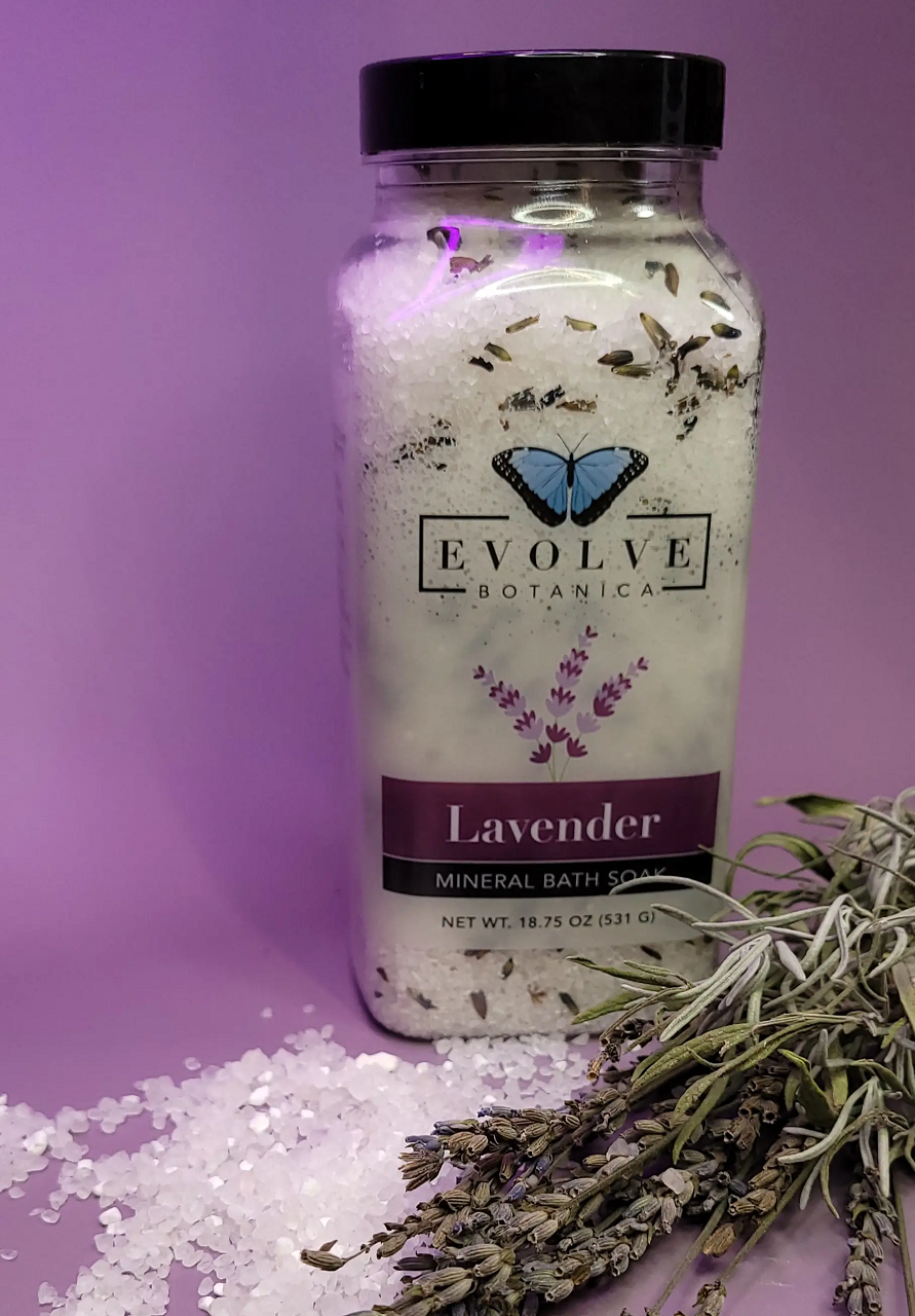 A jar of Mineral Soak - Lavender Spa bath salt, featuring lavender flowers and a soothing purple hue, perfect for relaxation.