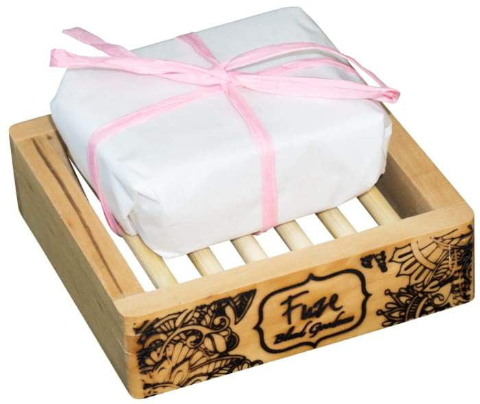 Monthly Comfort Burst Bar with essential oils and fizzing bath bomb pockets, displayed on a wooden soap dish.