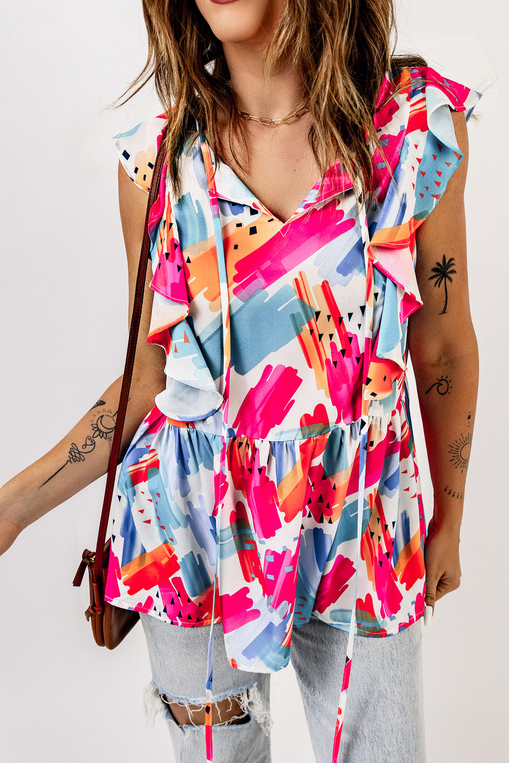 Multicolor abstract print tank top featuring a v-neckline and ruffled cap sleeves, perfect for summer wear.