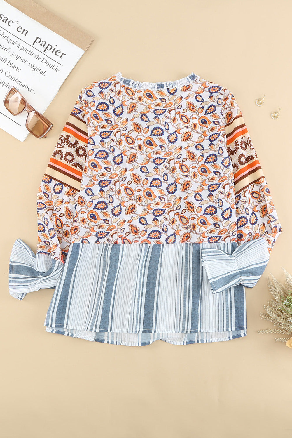 A vibrant multicolor loose fit floral striped blouse featuring a v-cut neckline, tie closure, and long flared sleeves, perfect for casual outings.