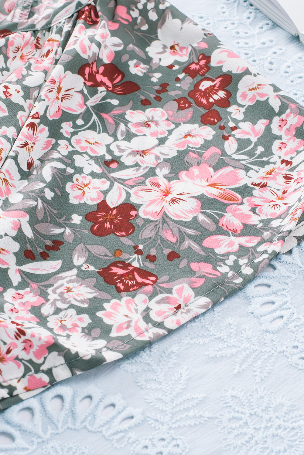 A vibrant multicolor V-neck blouse with short ruffled sleeves and a fluttering hem, showcasing an elegant fashion print.