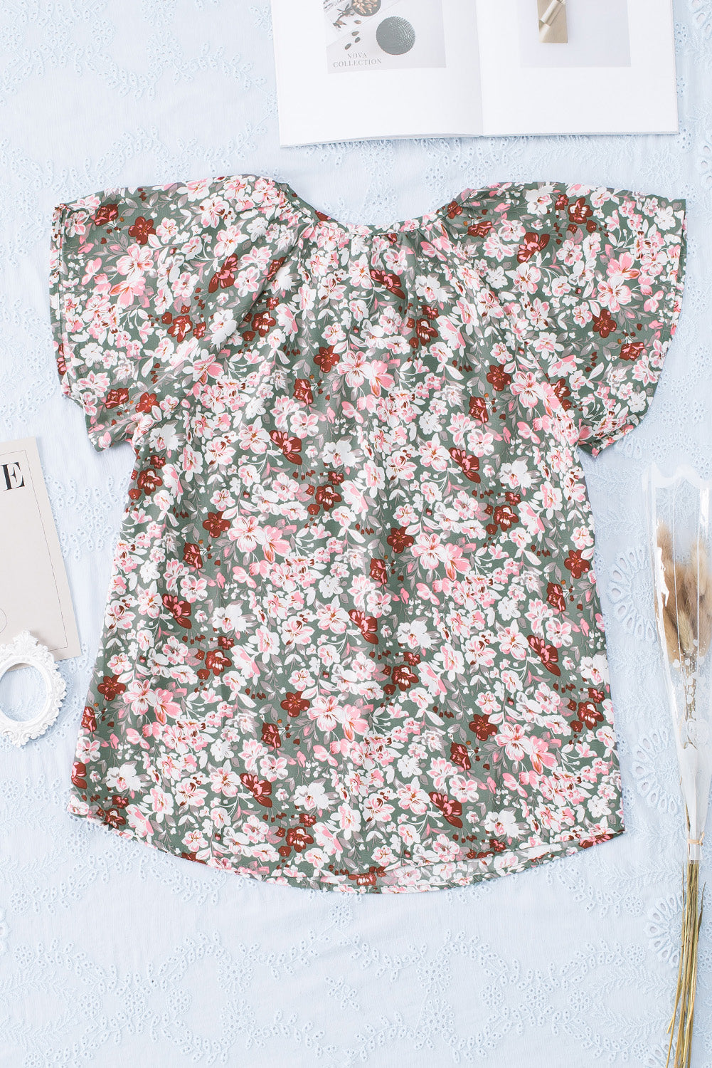 A vibrant multicolor V-neck blouse with short ruffled sleeves and a fluttering hem, showcasing an elegant fashion print.