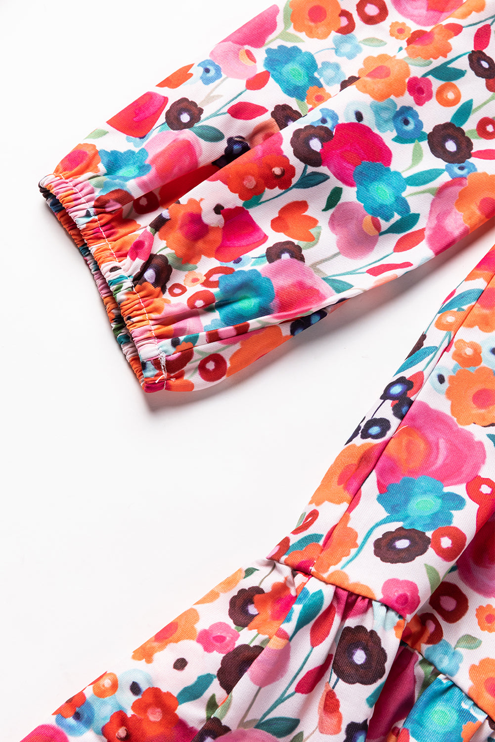 A vibrant multicolour floral dress featuring a ruffle split neck, long sleeves, and a boho chic style, perfect for casual and semi-formal occasions.