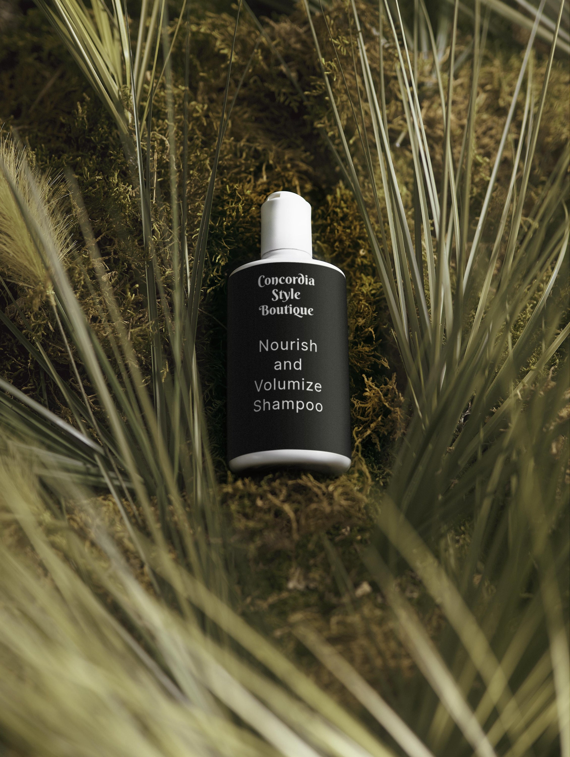 A bottle of Nourish and Volumize Shampoo with a sleek white design, showcasing its nourishing ingredients for healthy hair.