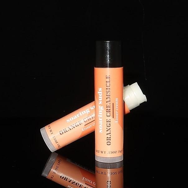 Orange Creamsicle Kisser Cream lip balm tube with a vibrant orange design, showcasing its natural ingredients and moisturizing properties.
