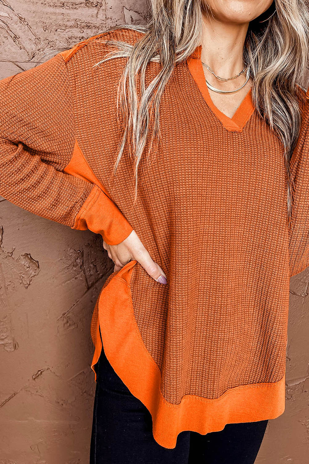 Orange waffle knit long sleeve top with patchwork design and v neckline, perfect for autumn and winter fashion.
