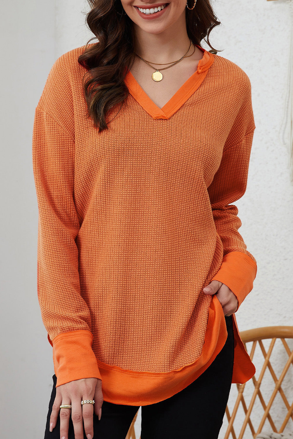 Orange waffle knit long sleeve top with patchwork design and v neckline, perfect for autumn and winter fashion.