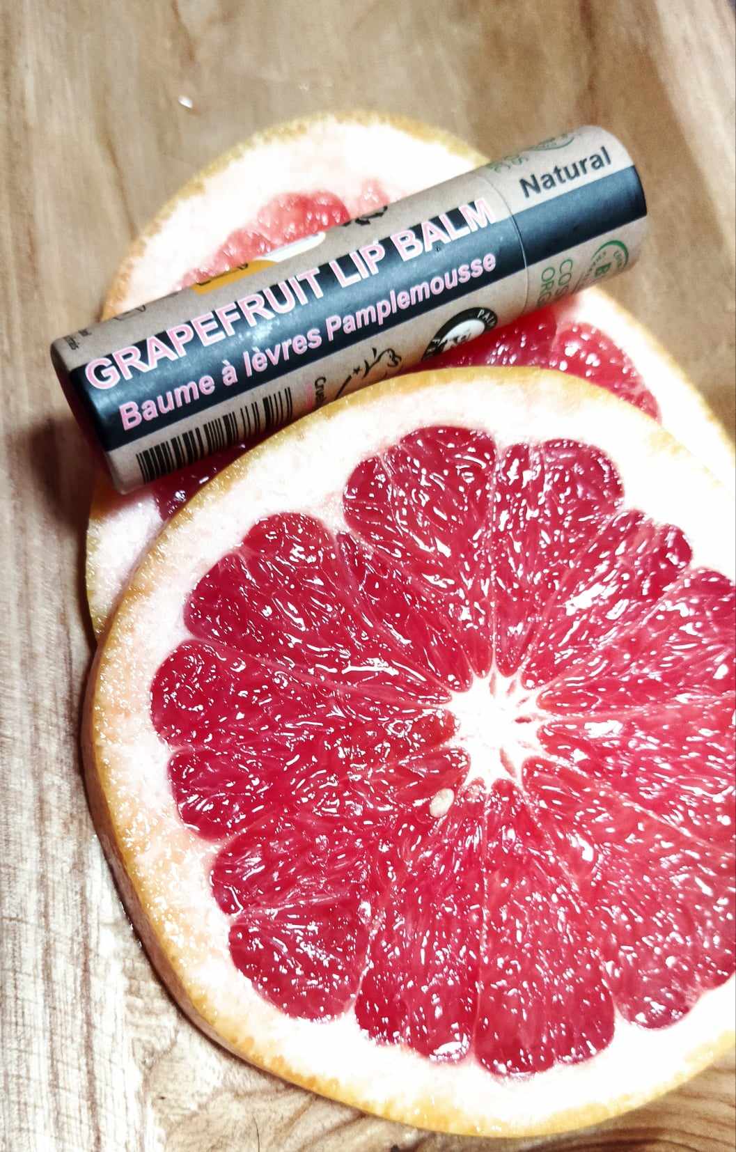 Organic Pink Grapefruit Lip Balm in a paper tube, showcasing its natural ingredients and eco-friendly packaging.