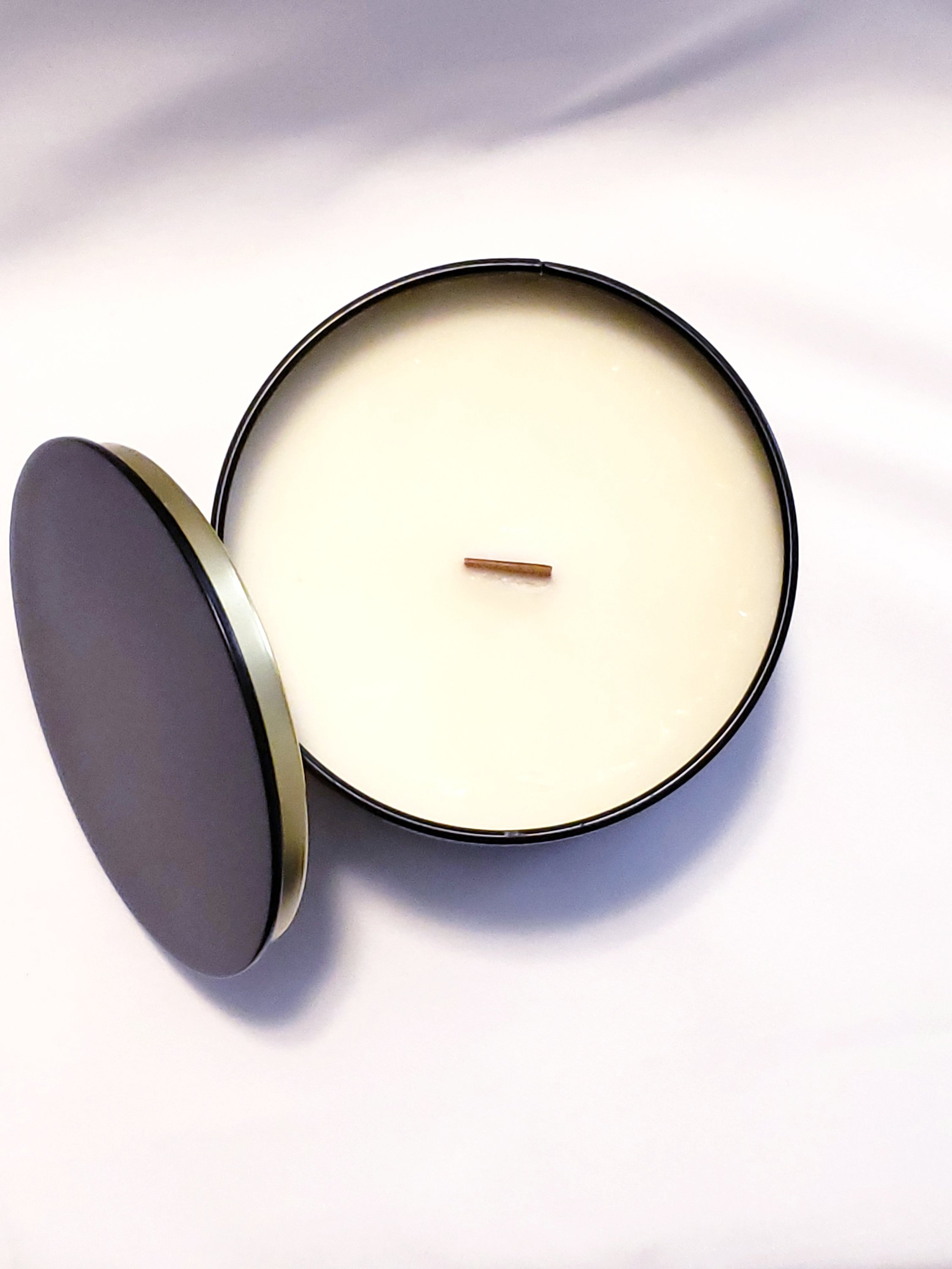 Pacific Trail Candle in a glass jar with a natural wood lid, showcasing its earthy and floral scent profile.