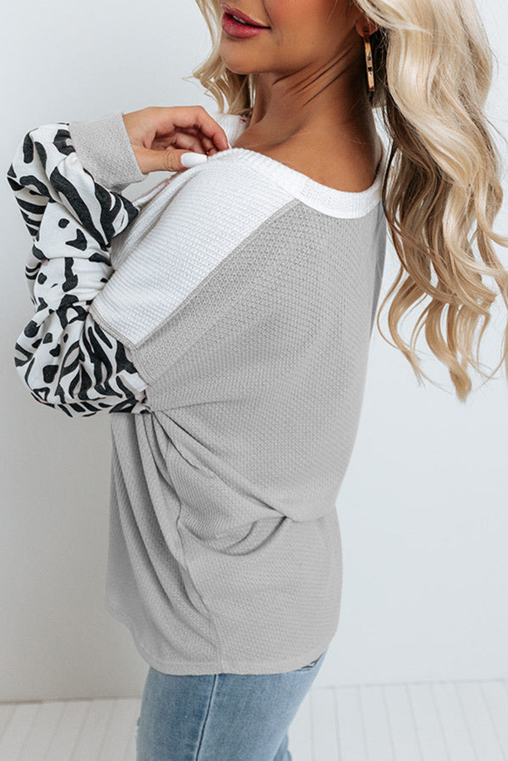 Parchment Leopard Sleeve Patchwork Waffle Knit Top featuring trendy leopard print sleeves and exposed seam detailing.