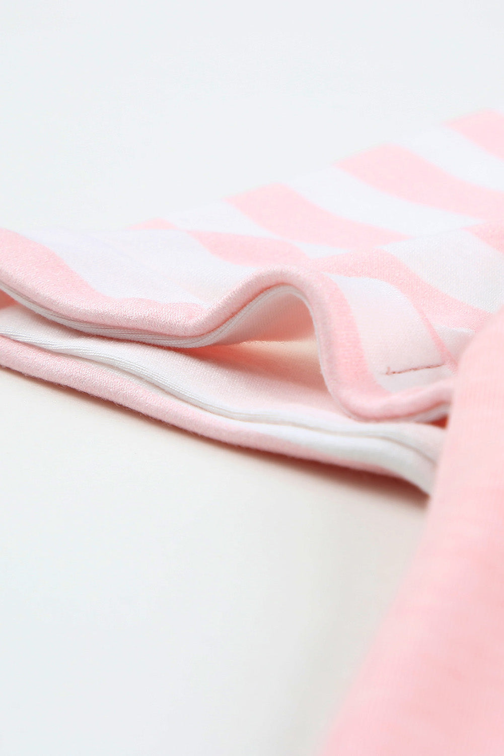 A stylish pink crewneck t-shirt featuring raglan sleeves with striped patchwork design, perfect for summer wear.