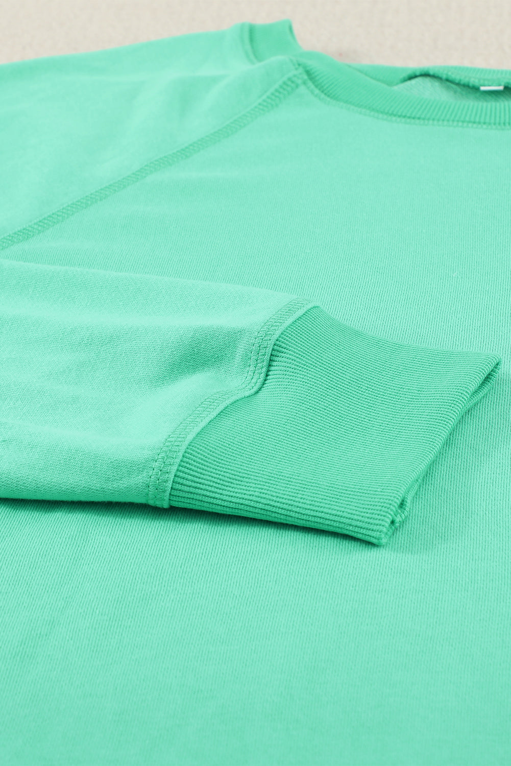 A stylish pink French terry cotton blend pullover sweatshirt featuring a crew neckline, long sleeves, and distressed detailing for a relaxed look.