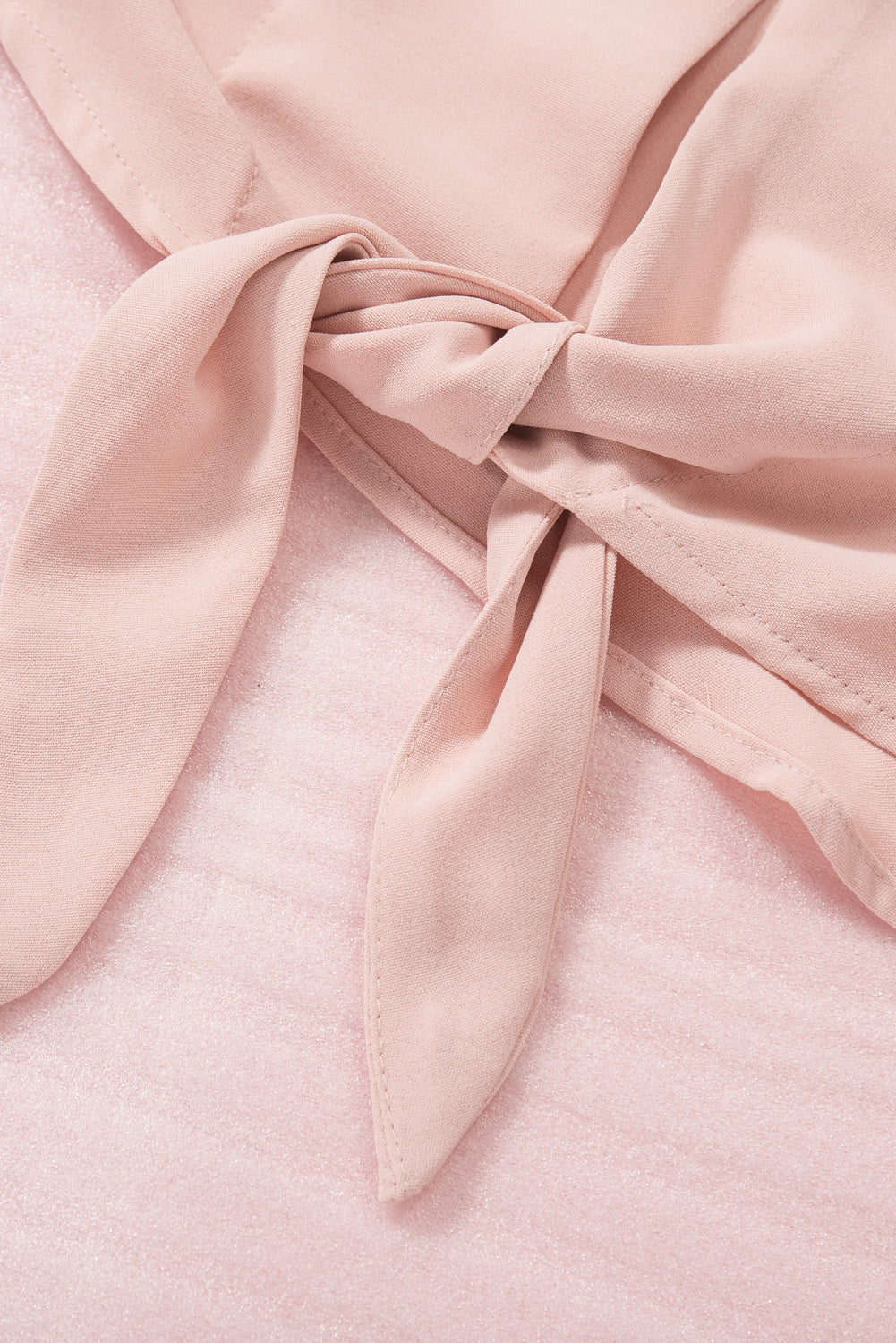 A stylish pink blouse featuring a V neck, lace splicing cuffs, and a button knotted design, perfect for casual and formal wear.