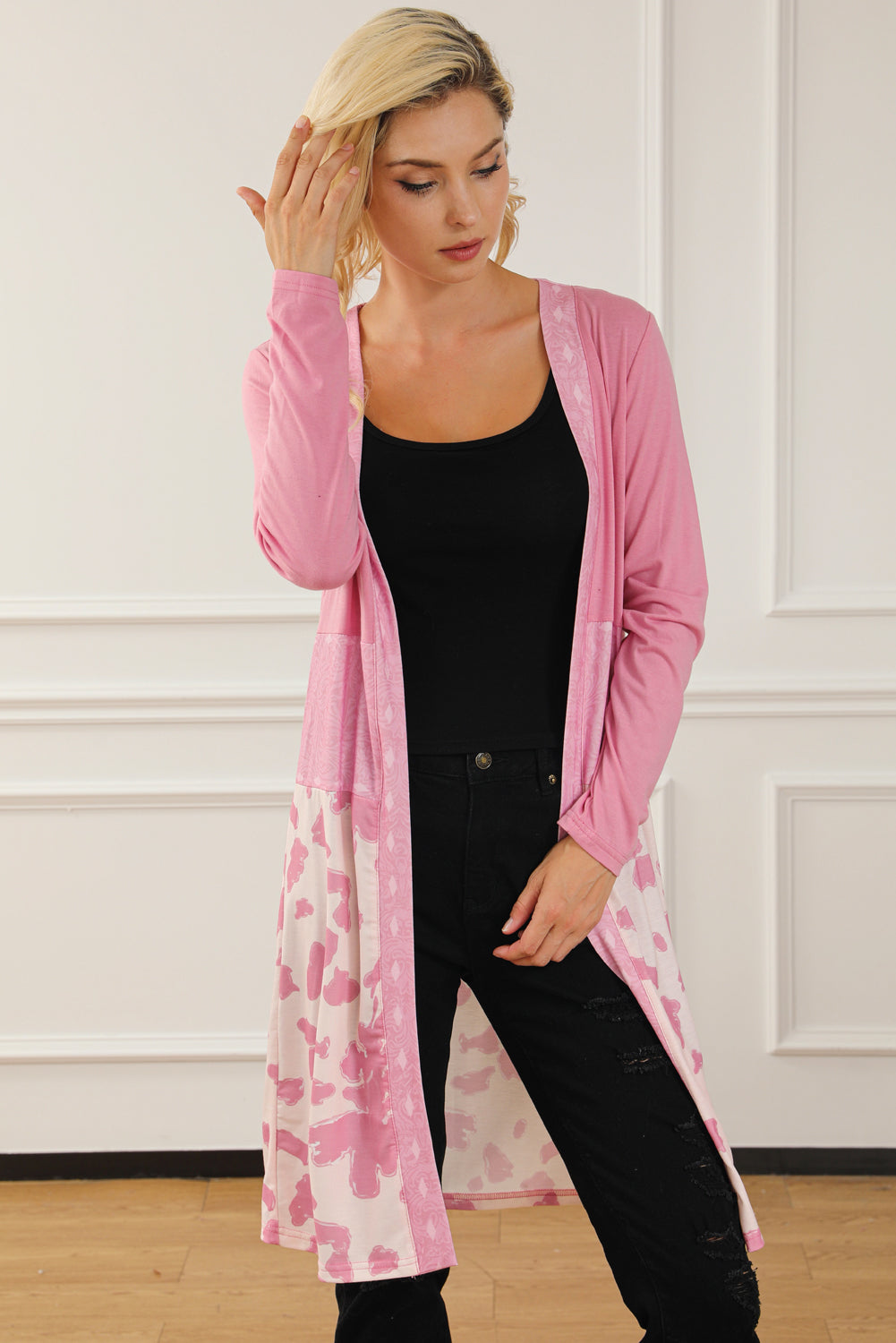 A stylish pink cardigan featuring a western cow patchwork design, open front style, perfect for casual wear.