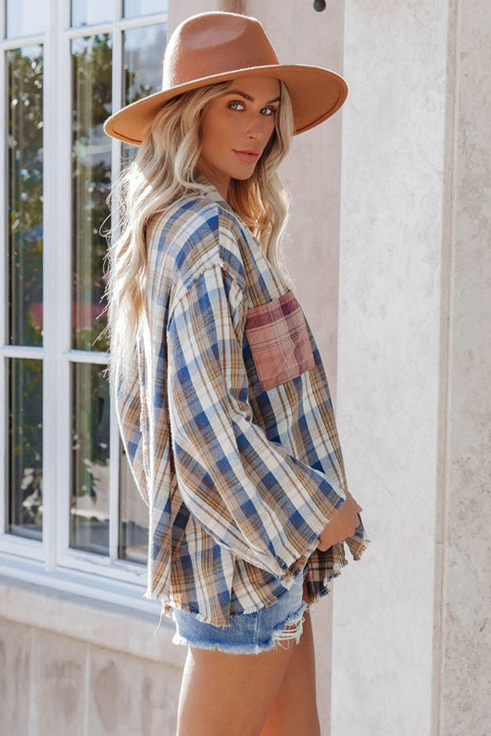 A stylish plaid pattern shirt featuring an asymmetric design, multicolor hues, and a frayed hemline, perfect for casual and vintage looks.