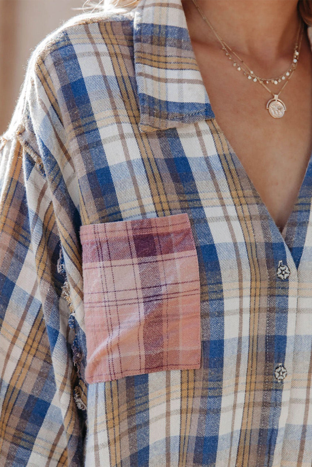 A stylish plaid pattern shirt featuring an asymmetric design, multicolor hues, and a frayed hemline, perfect for casual and vintage looks.