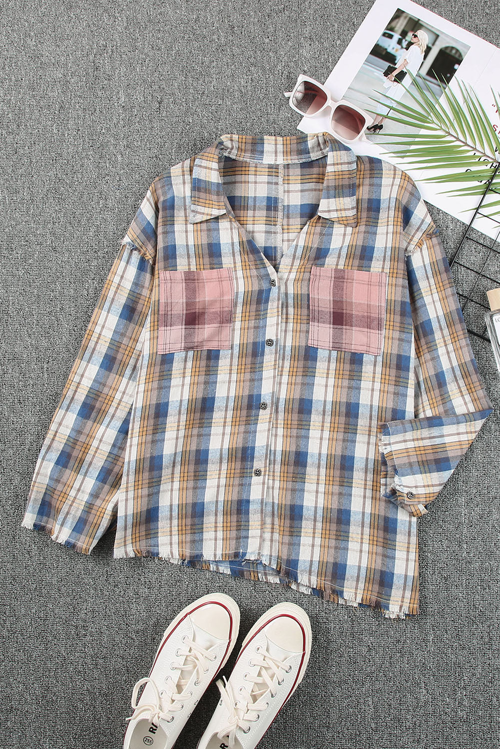 A stylish plaid pattern shirt featuring an asymmetric design, multicolor hues, and a frayed hemline, perfect for casual and vintage looks.
