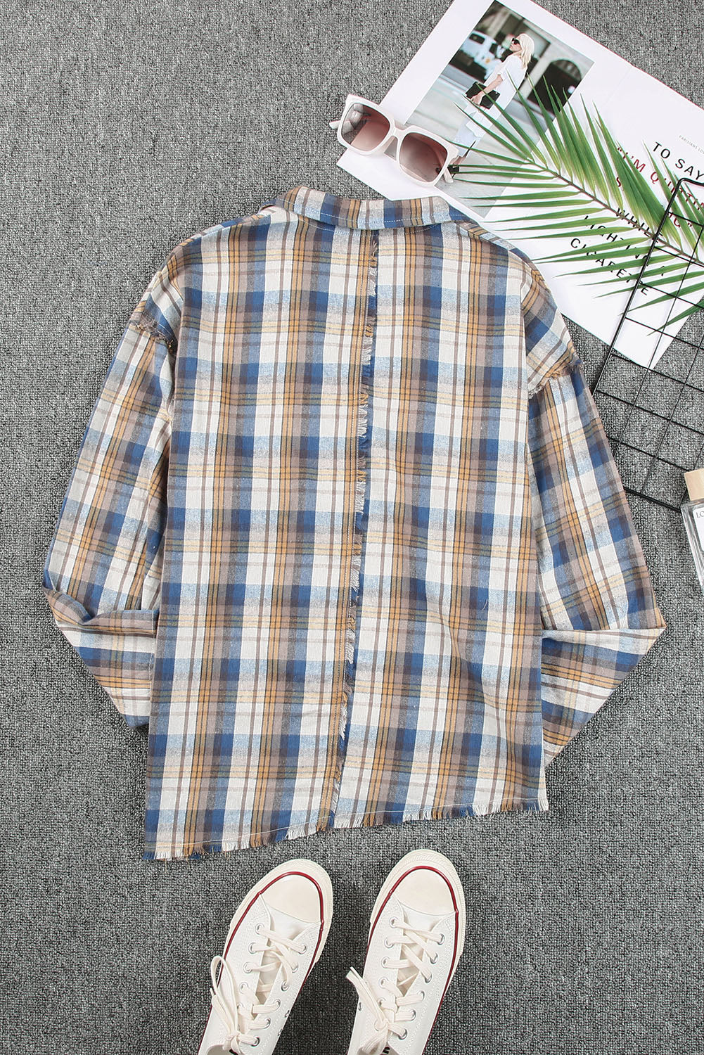 A stylish plaid pattern shirt featuring an asymmetric design, multicolor hues, and a frayed hemline, perfect for casual and vintage looks.