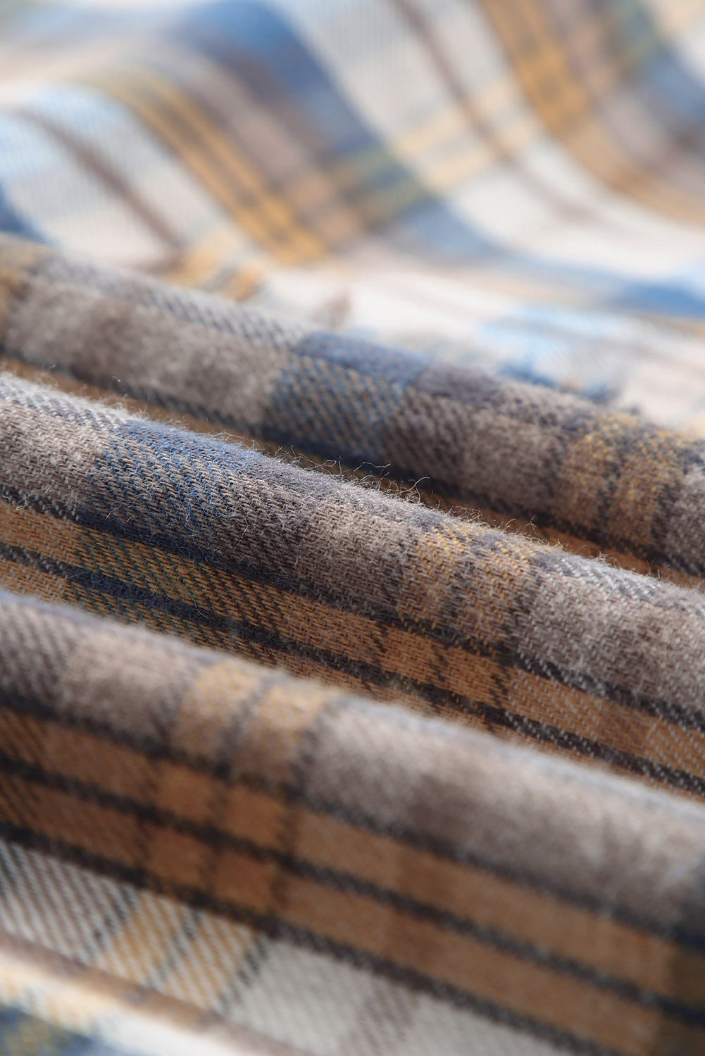 A stylish plaid pattern shirt featuring an asymmetric design, multicolor hues, and a frayed hemline, perfect for casual and vintage looks.