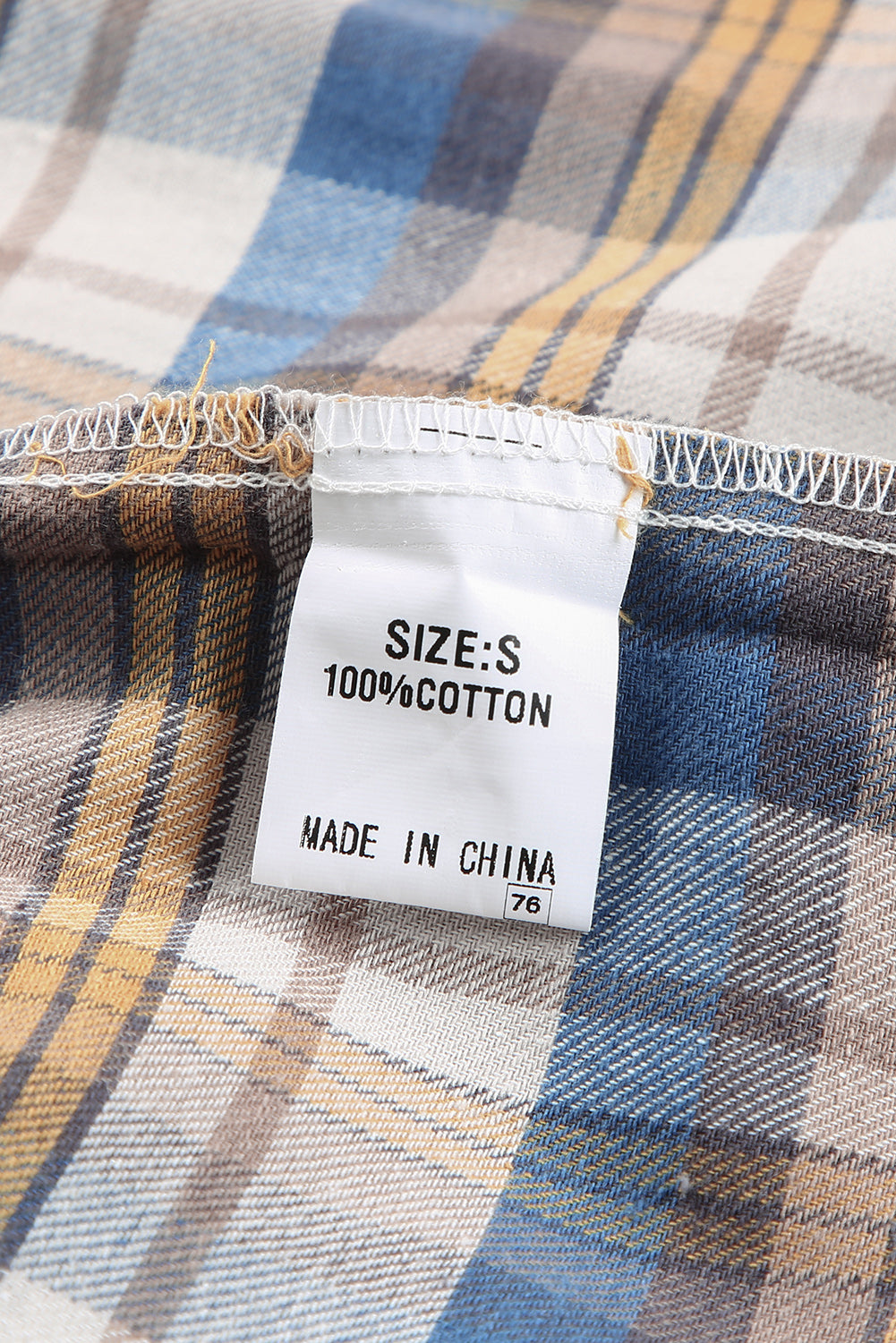 A stylish plaid pattern shirt featuring an asymmetric design, multicolor hues, and a frayed hemline, perfect for casual and vintage looks.