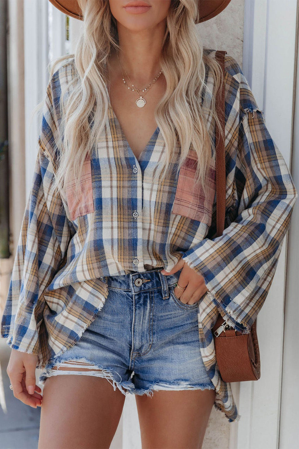 A stylish plaid pattern shirt featuring an asymmetric design, multicolor hues, and a frayed hemline, perfect for casual and vintage looks.