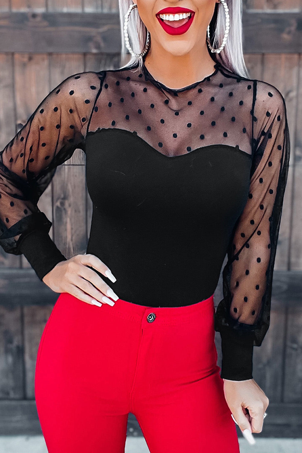 A stylish black long sleeve bodysuit featuring sheer mesh splicing with a polka dot pattern, perfect for versatile outfits.