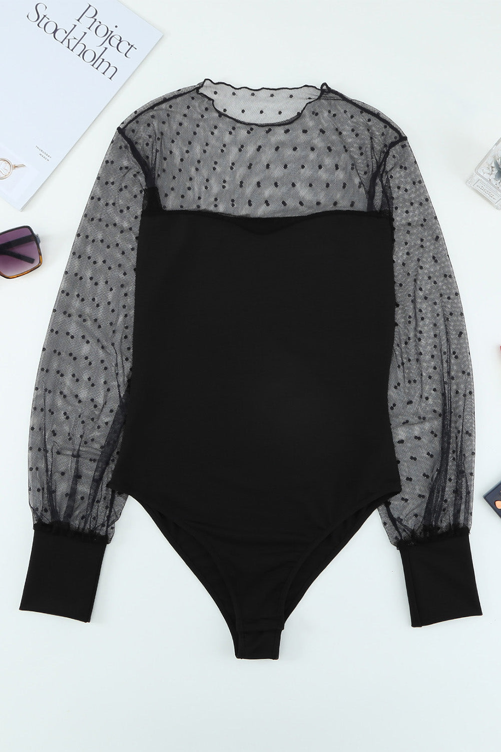 A stylish black long sleeve bodysuit featuring sheer mesh splicing with a polka dot pattern, perfect for versatile outfits.