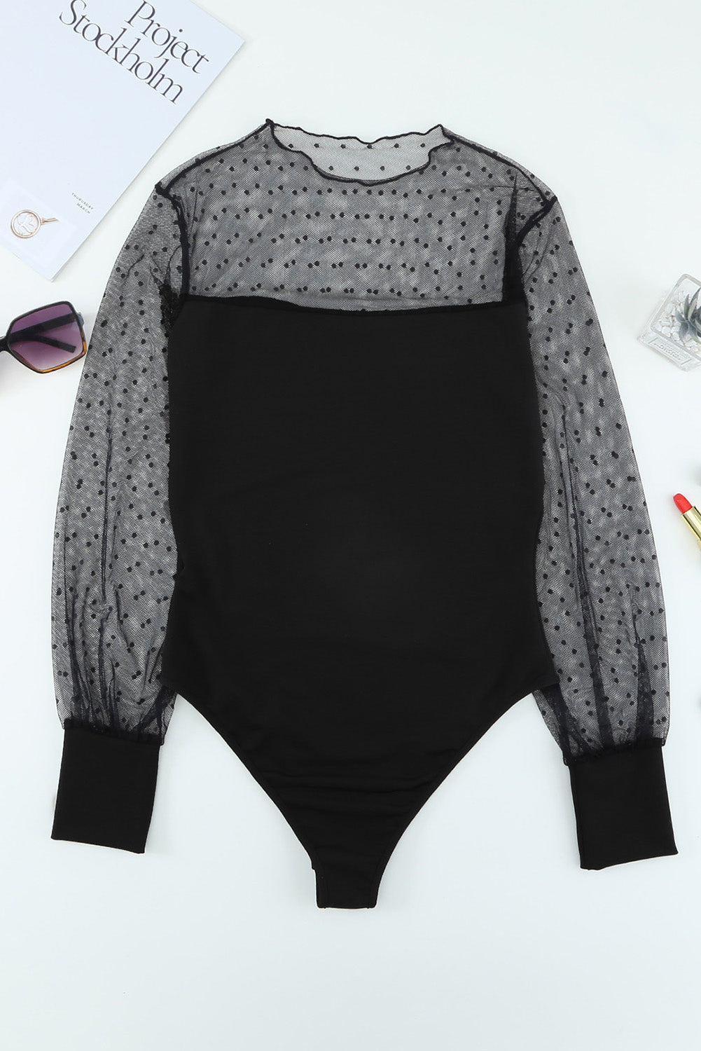 A stylish black long sleeve bodysuit featuring sheer mesh splicing with a polka dot pattern, perfect for versatile outfits.