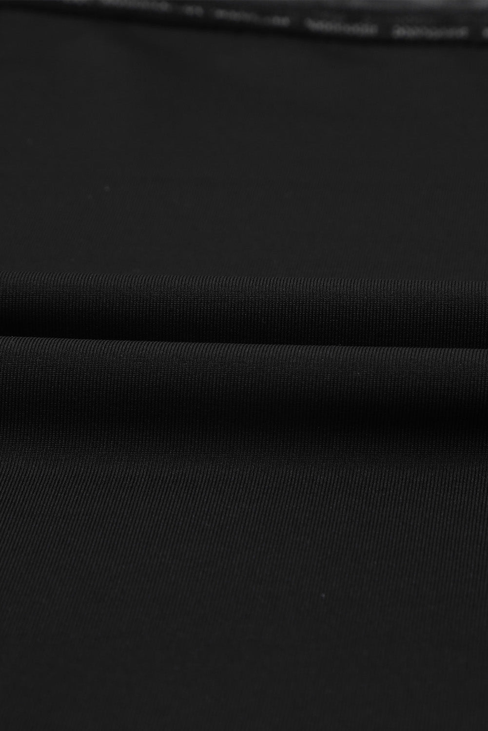 A stylish black long sleeve bodysuit featuring sheer mesh splicing with a polka dot pattern, perfect for versatile outfits.