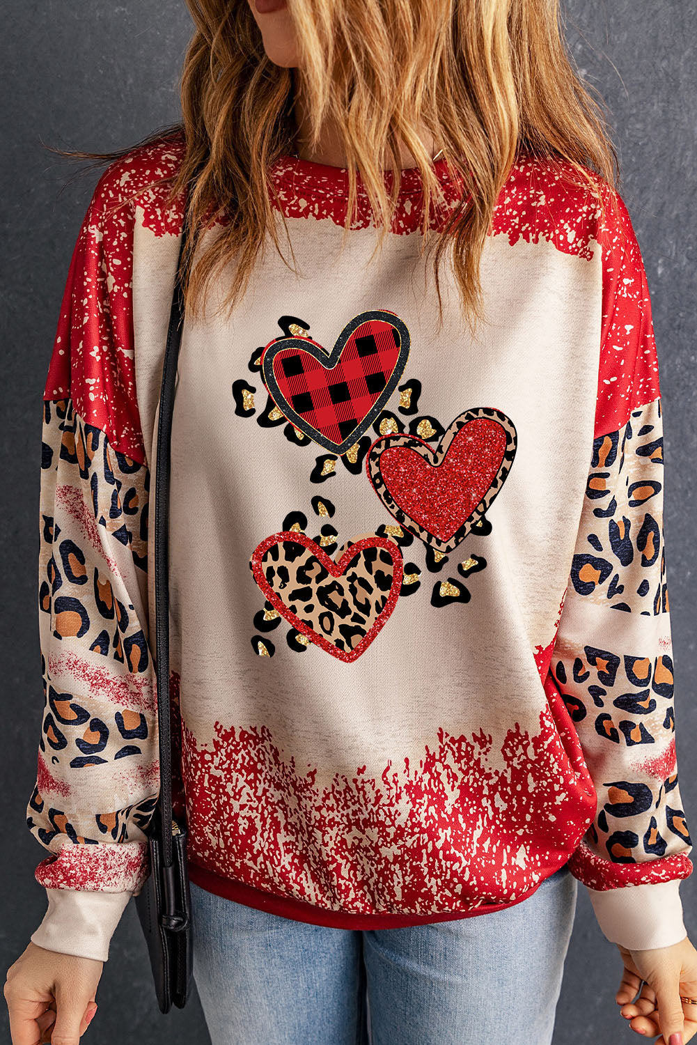 Red pullover sweatshirt featuring a heart-shaped leopard print design with a bleached effect, perfect for casual wear.